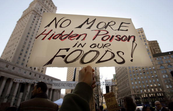 NEW YORK - OCTOBER 30: A protester holds a sign reading "No More Hidden Poison in Our Foods" at a rally against trans fats October 30, 2006 in New York City. The city's health department is holding public hearings on a proposed ban of trans fats, which increases the so-called "bad cholesterol" content of food. (Photo by Mario Tama/Getty Images)